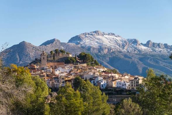 A hilltop village with the snow-capped Sierra de Aitana behind