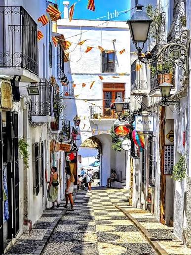 A narrow old-town street strung with festival bunting