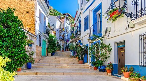 Whitewashed steps with blue doors and potted plants